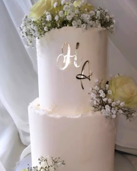 Gâteau de mariage blanc décoré de fleurs de gypsophile et d’initiales argentées – Cake by Audrey à Le Thor (Vaucluse)